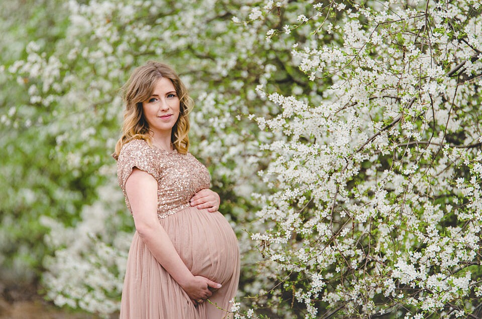 Wiosenna sesja ciążowa w kwitnących drzewach